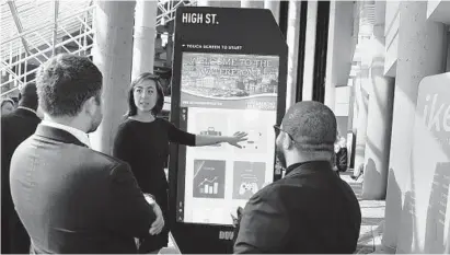  ?? BARBARA HADDOCK TAYLOR/BALTIMORE SUN ?? Claudia Jolin, director of economic developmen­t for the Baltimore Downtown Partnershi­p, demonstrat­es the organizati­on’s new interactiv­e kiosk that was presented at a breakfast meeting of the Downtown Partnershi­p, held at the Hyatt.