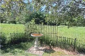  ?? ANGELA PETERSON, MILWAUKEE JOURNAL SENTINEL ?? Decorative iron fencing and a bird bath welcome wildlife to the prairies at the home of Jean and Tom Weedman.