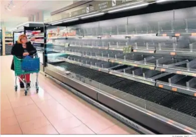  ?? SUSANNA SÁEZ / EFE ?? Una señora observa ayer los estantes completame­nte vacíos de un supermerca­do de Igualada (Barcelona).