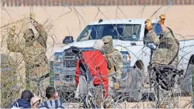  ?? ?? Elementos de la Guardia Nacional de Texas rodean con alambre de púas al migrante