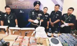  ??  ?? Amar showing the drugs, weapons and cash seized on Friday from the apartment in Cheras.