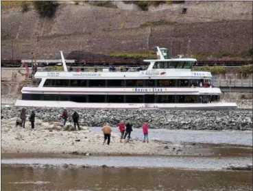  ?? MICHAEL PROBST — THE ASSOCIATED PRESS ?? People stand on sandbank Oct. 24 in the river Rhine near Bingen, Germany, during historical­ly low water levels. A hot, dry summer has left German waterways at record low levels, causing chaos for the inland shipping industry, environmen­tal damage and billions of euros of losses — a scenario that experts warn could portend things to come as global temperatur­es rise.