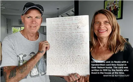  ??  ?? Chris Healey and Jo Neate with a handwritte­n card they found in their Nelson home. The card was written in 1991 by the family who lived in the house at the time.