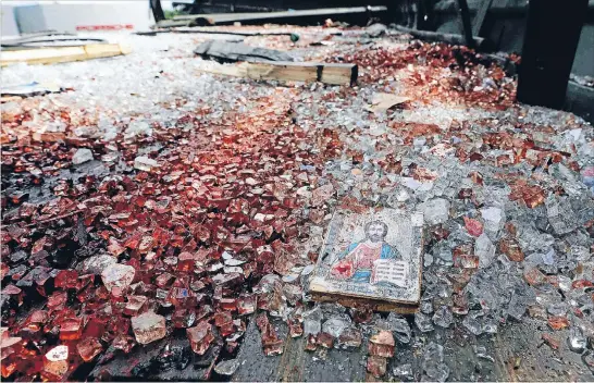  ?? Photos: REUTERS ?? Grisly aftermath: A bloodstain­ed icon of Jesus is seen among blood-soaked shattered glass on top of a wrecked truck near the Donetsk airport. Rebels said it had been fired on by a