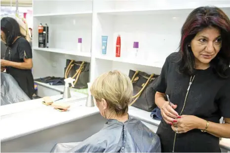  ?? PHOTOS: NEV MADSEN ?? DIRECTOR’S CUT: Yvonne Bou-Samra recalls her 40 years in the Intershape Hairstylis­ts salon in the Wilsonton Shopping Centre while giving a final cut to long-time client Judy Gardiner.