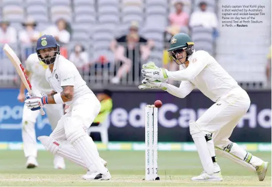  ??  ?? India’s captain Virat Kohli plays a shot watched by Australia’s captain and wicket-keeper Tim Paine on day two of the second Test at Perth Stadium in Perth. — Reuters