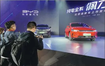  ?? ZHANG DANDAN / CHINA DAILY ?? BYD launches its new electric models, including the 2021 Tang EV and the Qin Plus EV, last week in Chongqing. The new SUV and sedan are equipped with the automaker’s self-developed blade-shaped batteries.