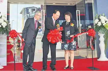  ??  ?? Wong (centre) with UOB Malaysia area manager of East Malaysia Chua Chai Hua (left) and UOB Malaysia Kuching branch manager Emily Rolanda Yong during the ribbon cutting ceremony yesterday.