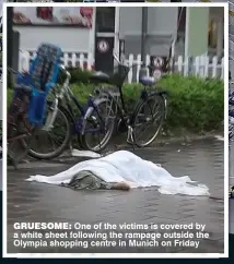  ??  ?? GRUESOME: One of the victims is covered by a white sheet following the rampage outside the Olympia shopping centre in Munich on Friday