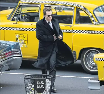  ??  ?? Cumberbatc­h in a dark coat and glasses next to a New York-style taxi in Glasgow yesterday