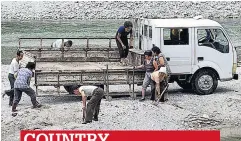  ??  ?? COUNTRY Elderly women load rocks from a river bed on to a truck