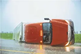  ?? CHRIS MACHIAN/ OMAHA WORLD-HERALD ?? A semitruck rests on its side in the eastbound lanes of Interstate 40, just east of El Reno, Okla., after a tornado touched down during rush hour. Officials reported numerous injuries along the interstate.