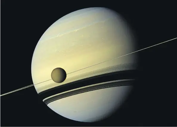  ?? NASA/THE ASSOCIATED PRESS ?? Saturn’s largest moon, Titan, passes in front of the giant ringed planet in an image made by NASA’s Cassini spacecraft. Titan is larger than both Mercury and Pluto.