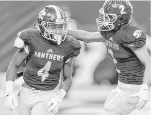  ?? Wilf Thorne ?? Ridge Point’s B.J. Rainford (4) earns a pat on the back from teammate Adam Bazan after scoring a touchdown in the first half of Saturday’s Class 5A Division II area-round game at NRG Stadium.