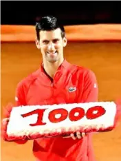  ?? AFP/VNA Photo ?? GRAND MASTER :Serbia's Novak Djokovic holds a cake marking his record of 1,000 match wins on the ATP Tour.