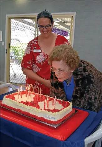  ?? Photo: Alexia Austin ?? CELEBRATIO­N: Glenvale Villas aged care nurse Berenice Cojean (left) helps Dorothy Hancock to blow out the candles on her 100th birthday cake.
