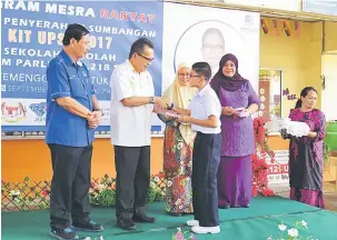  ??  ?? SEMOGA BERJAYA: Ahmad Lai (dua kiri) menyampaik­an Kit UPSR kepada salah seorang murid SK Temenggung Datuk Muip sambil disaksikan Hamisah (dua kanan) semalam.