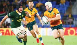  ?? — AFP file photo ?? Hooper (right) runs with the ball during the Rugby Championsh­ip match against South Africa at Cbus Super Stadium in Gold Coast.