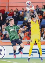  ?? Michael Wyke/Associated Press ?? Dynamo goalkeeper Steve Clark, right, makes one of his four saves during Saturday’s win over Austin FC.