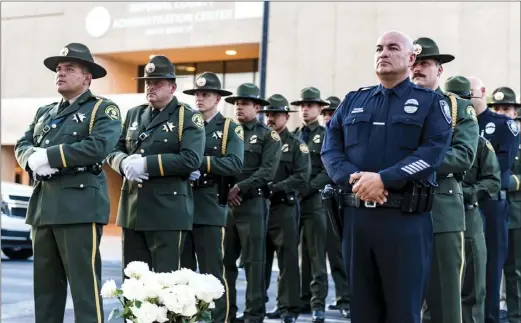  ?? VINCENT OSUNA PHOTO ?? Members of local law enforcemen­t line up in order to carry a white rose in honor of the local fallen law enforcemen­t officers during the 10th annual Imperial Valley Law Enforcemen­t Memorial Ceremony held at the Superior Courthouse on Friday in El Centro.