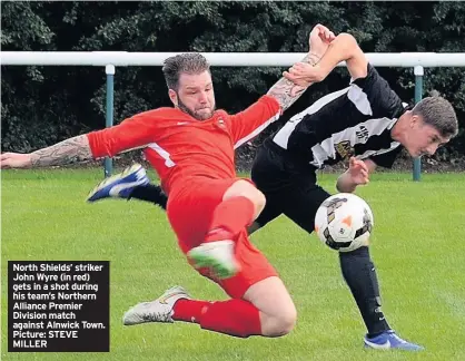  ??  ?? North Shields’ striker John Wyre (in red) gets in a shot during his team’s Northern Alliance Premier Division match against Alnwick Town. Picture: STEVE MILLER