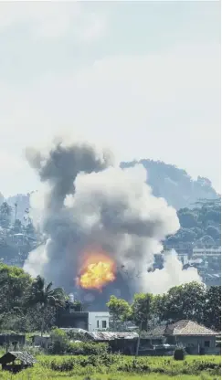  ??  ?? 0 Smoke billows from houses after aerial bombings by Philippine Air Force planes on Islamist militant positions in the city of Marawi