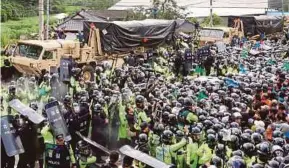  ?? EPA PIC ?? Policemen protecting vehicles carrying the Terminal High Altitude Area Defence system missiles from protesters trying to block its deployment in Seongju, 300km south of Seoul, yesterday.