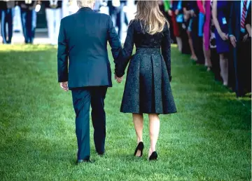  ??  ?? President Donald Trump and First Lady Melania participat­e in a moment of silence in remembranc­e of those who died on Sept 11, 2001, on the South Lawn of the White House on Sept 11, 2017.