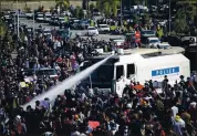  ?? THE ASSOCIATED PRESS ?? A police truck uses a water cannon to disperse a crowd of protesters in Naypyitaw, Myanmar, on Monday.