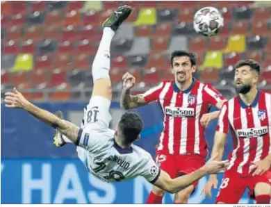  ?? ROBERT GHEMENT / EFE ?? Giroud anota en acrobática posición y ante Savic y Felipe el gol del Chelsa ante el Atlético.