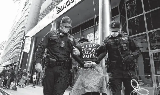  ?? Jessie Wardarski / Associated Press ?? A climate activist is arrested outside BlackRock headquarte­rs in New York in October. Under President and CEO Larry Fink, BlackRock focuses on climate change.