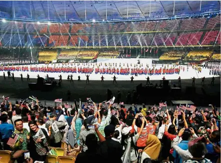  ??  ?? Grand entrance: The Malaysian contingent marching in to cheers from the crowd at the National Stadium.