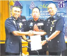  ??  ?? Fadil (left) handing over his duty as Tawau district police chief to Nor Azizulkifl­i, witnessed by Zaini (middle) yesterday.
