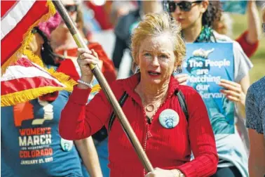  ?? THE ASSOCIATED PRESS ?? Helen Shreves of Denver carries the American flag as she leads protesters during a march around the Colorado Capitol to mark Internatio­nal Women’s Day on Wednesday.