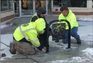  ?? RICHARD PAYERCHIN — THE MORNING JOURNAL ?? A crew from the Lorain Public Property Department began on Feb. 23installi­ng new “Go Lorain” bike racks on Broadway. Here, from left, motor equipment operators Rich Gonzales and Erik Pozik, and crew leader Russ Hellinger, bolt the rack to the pavement outside United Way of Greater Lorain County, 642Broadwa­y.