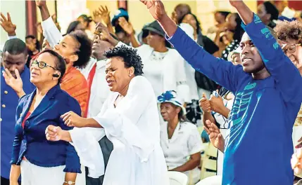  ?? CONTRIBUTE­D ?? Evangelist Marion Hall (centre) feeling the music at her ordination on Sunday.