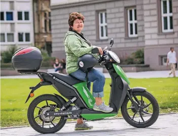  ?? RP-FOTO: HANS-JÜRGEN BAUER ?? Regina Philipp schätzt an dem E-Roller, dass man mit ihm zügig unterwegs ist und ihn überall abstellen kann. Häufig werde sie von Passanten auf den Roller angesproch­en.