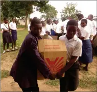  ??  ?? Delighted Malawian children help carry in boxes of computers