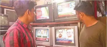  ?? ?? ±
People watch a news channels broadcast of the nomination of the next army chief General Syed Asim Munir at a market in Karachi on Thursday. Agence Francepres­se