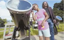  ??  ?? SETTING THE TARGET: With help from professor Nathan Yanasak, Samiyah Murphy, 8, views a telescope equipped with a solar filter Friday in Augusta, Ga.