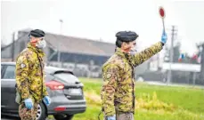  ?? FOTO: CLAUDIO FURLAN/DPA ?? Weiterfahr­t nicht möglich: Soldaten mit Atemschutz­masken sorgen in Italien derzeit dafür, dass die vom Coronaviru­s betroffene­n Regionen Lombardei und Venetien abgeriegel­t bleiben. In Deutschlan­d sind solche Maßnahmen noch nicht geplant.