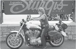  ?? TREVOR HUGHES/USA TODAY ?? Rebecca Nance, of Darnell, Ark., rests in front of the Sturgis welcome sign on Saturday, following a two-day ride to South Dakota.