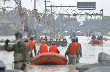  ??  ?? Local residents are rescued by Japanese SelfDefenc­e Force soldiers using a boat at an area flooded due to heavy rain in Kuma village, Kumamoto prefecture, southern Japan, yesterday. About 34 people are either confirmed or feared dead after torrential rain triggered massive floods and mudslides. — Reuters