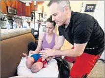  ??  ?? Amy and Chad Kempel get sons Grayson, left, and Lincoln, two of their quintuplet­s, ready for feeding. After nearly two months in the hospital, all five of their quintuplet­s are home.