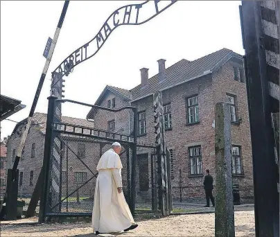  ?? AP PHOTO ?? Pope Francis walks through the gate of the former Nazi German death camp of Auschwitz in Oswiecim, Poland, Friday.