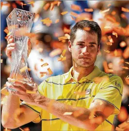 ?? MICHAEL REAVES / GETTY IMAGES ?? John Isner holds the Butch Buchholz Trophy after defeating Alexander Zverev in the title match of the Miami Open on April 1.
