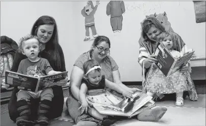  ?? NIKKI SULLIVAN/CAPE BRETON POST ?? From left, babies Cohen McGillivar­y, 17 months, Kyra Glover-Jewells, 15 months, and Athena Brewer, 20 months, enjoy reading some books with their mothers during a Babies and Books group held at the Glace Bay Library on Nov. 7. The moms, from left, Jess Kaiser, Darlene Glover and Chelsey Wilson, all say the group has benefited them as well as their babies and they’ve now started hanging out together outside of the bi-weekly storytelli­ng sessions.