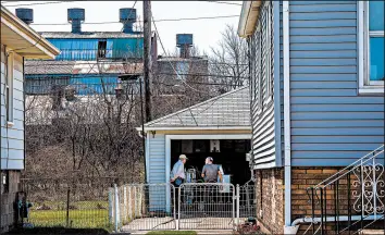  ?? ZBIGNIEW BZDAK/CHICAGO TRIBUNE ?? Neighbors Jeff Myers, 69, left, and Steve Krajnik, 80, talk in Hammond’s Robertsdal­e neighborho­od. The former site of Federated Metals can be seen behind the house.