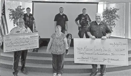  ?? COURTESY PHOTOS/MARION K9 PROJECT ?? The Marion K9 Project raised $42,700 for local K9 units at the Marion County Sheriff’s Office and Marion Police Department in 2023. Major B.J. Gruber, left, from the Marion Police Department and Sheriff Matt Bayles, right, from the Marion County Sheriff’s Office accept checks from Jill Chitwood, center, of the Marion K9 Project. Also shown are, from left to right, local K9 officers Deputy John Endicott, Det. Colin Lowe, and Deputy Sam Staley.