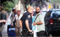  ??  ?? Police officers are seen by a crime scene where three people were shot in the Gowanus area of the Brooklyn Borough of New York City. — AFP photo